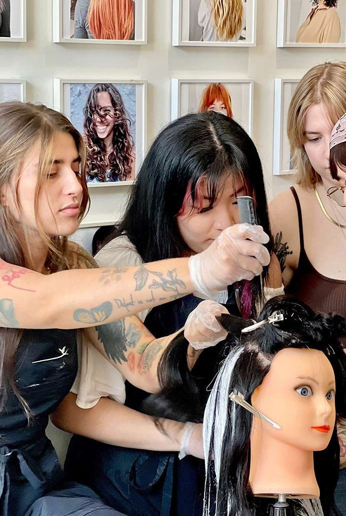 A hair styling educator with apprentices at The Bird House Hair Salon in Brooklyn, NY